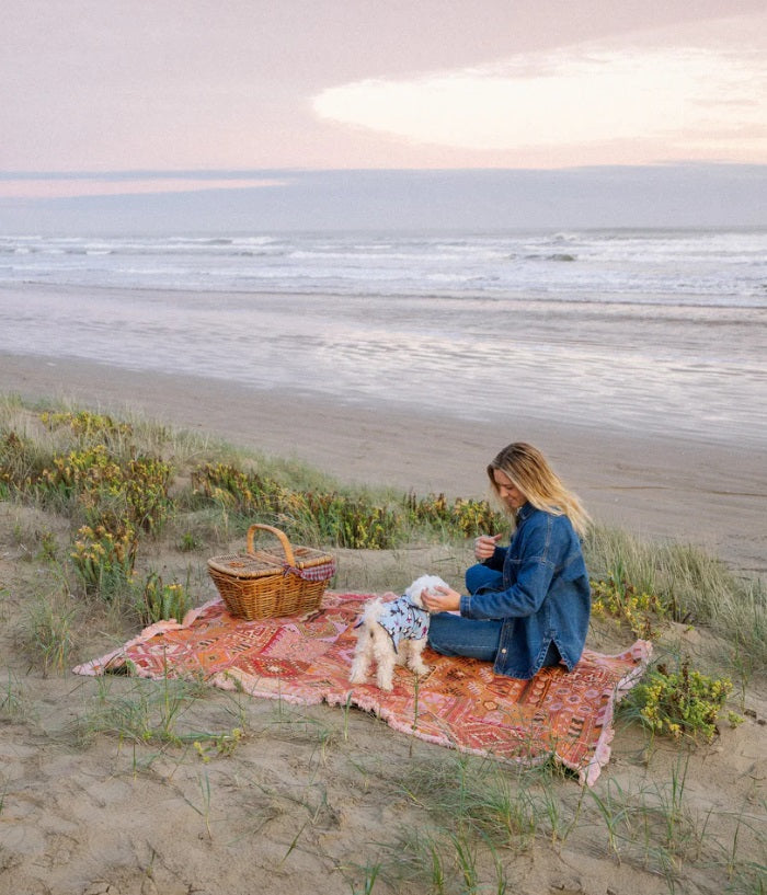 Person at the beach using the The Patchwork Rug by Salty Aura