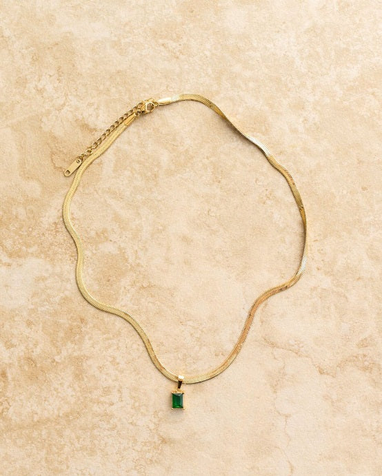 Flat lay of the Indigo & Wolfe Willow Necklace in Emerald 