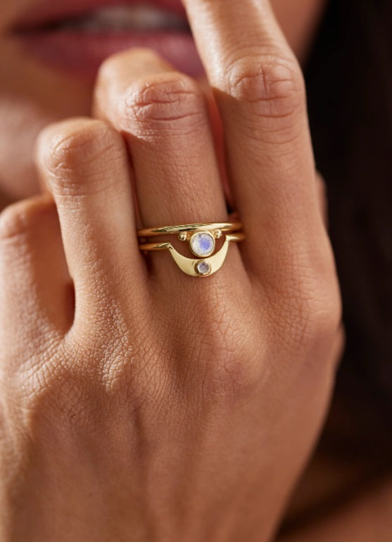 The Toni May Baby Gold Moonstone Crescent Ring stacked on model