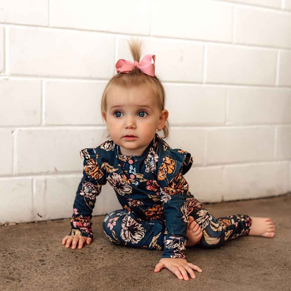Toddler on the floor wearing the Belle Organic Growsuit 