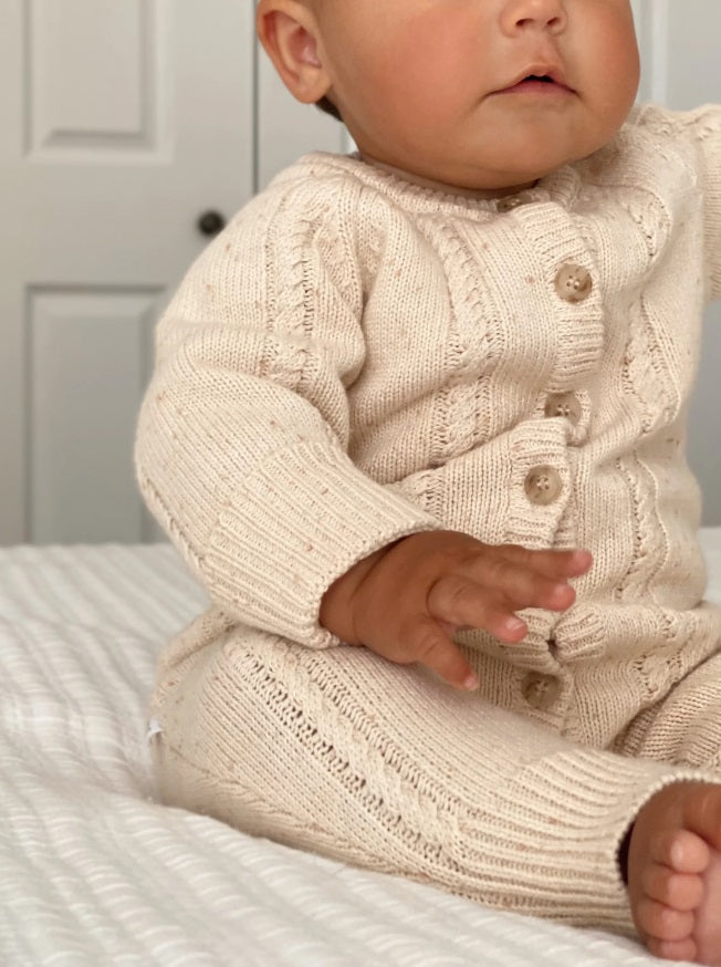 Baby wearing the Classic Knit Romper Biscotti Fleck by Ziggy Lou