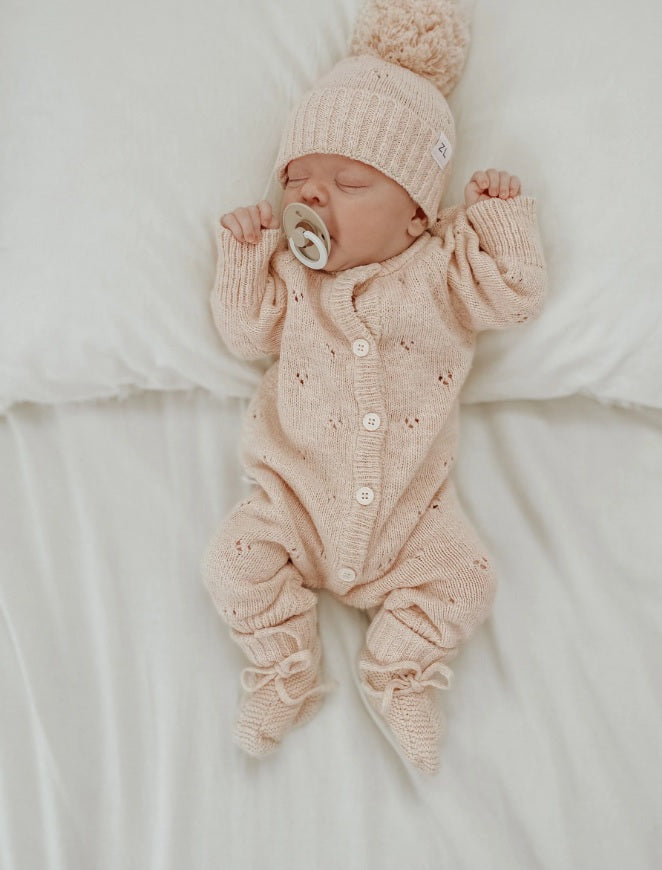 Baby wearing the Classic Knit Romper Petal by Ziggy Lou