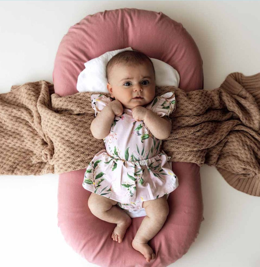 Baby laying down wearing the Cockatoo Organic Dress - Snuggle Hunny