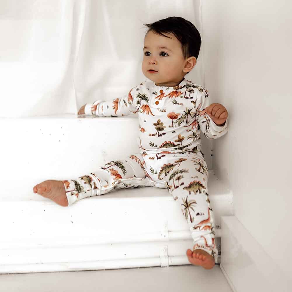 Toddler wearing dino organic growsuit by snuggle hunny
