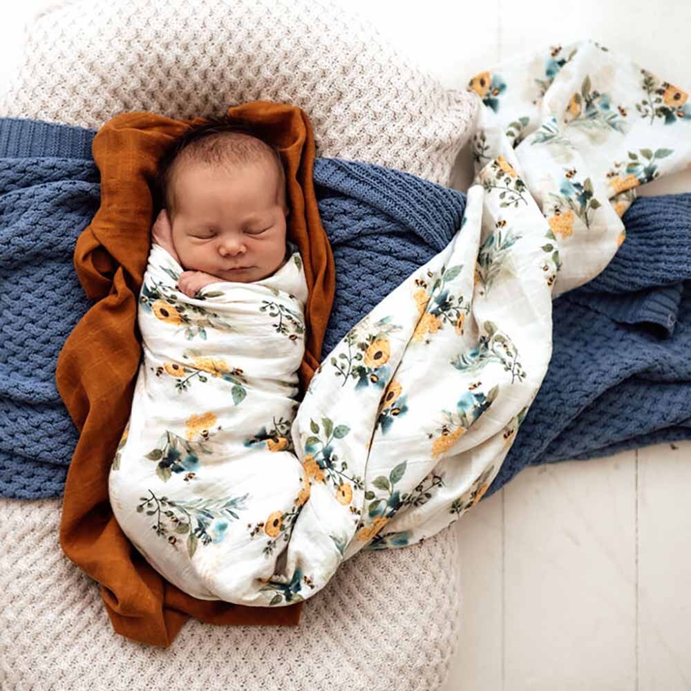 Baby sleeping wearing the Garden Bee Organic Muslin Wrap by Snuggle Hunny