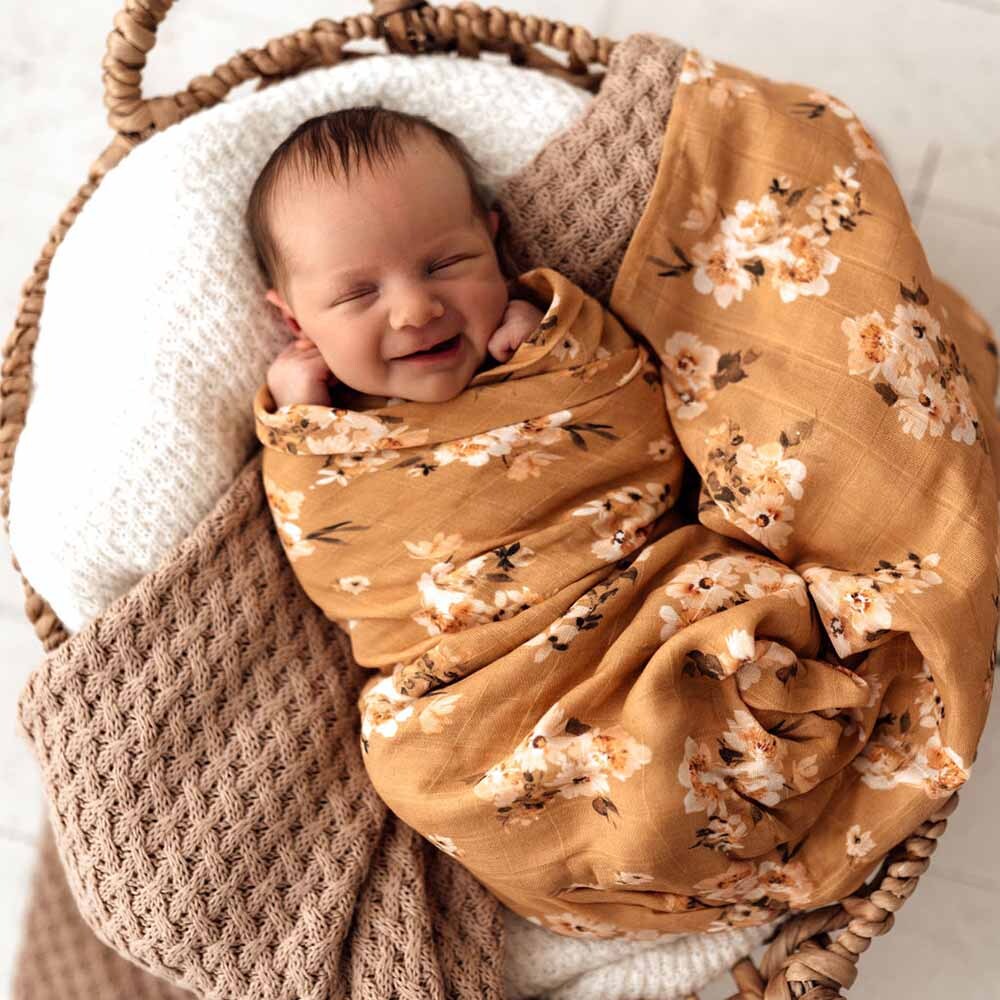 Baby asleep wearing the Golden Flower Organic Muslin Wrap by Snuggle Hunny