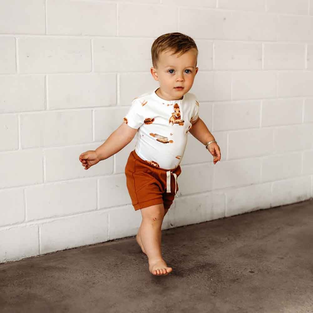 Toddler walking wearing Lion Short Sleeve Organic Bodysuit by Snuggle Hunny