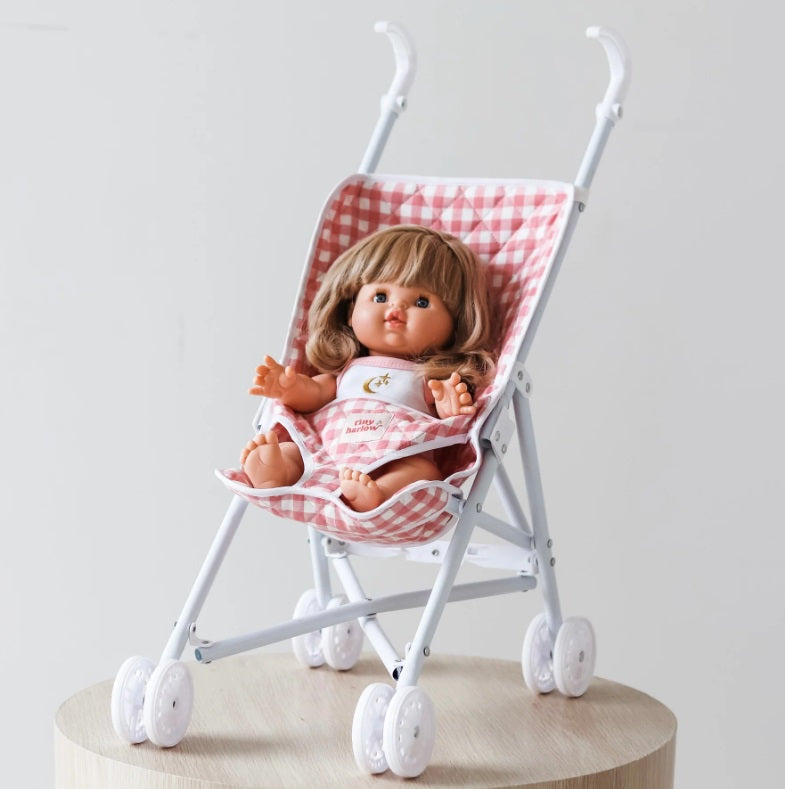 Doll sitting in the Pink Gingham Folding Doll's Stroller 2.0 by Tiny Harlow