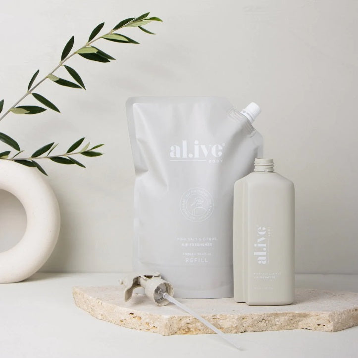 The Alive Body AIR FRESHENER REFILL - PINK SALT & CIRTUS 900ML sitting next to the bottle 