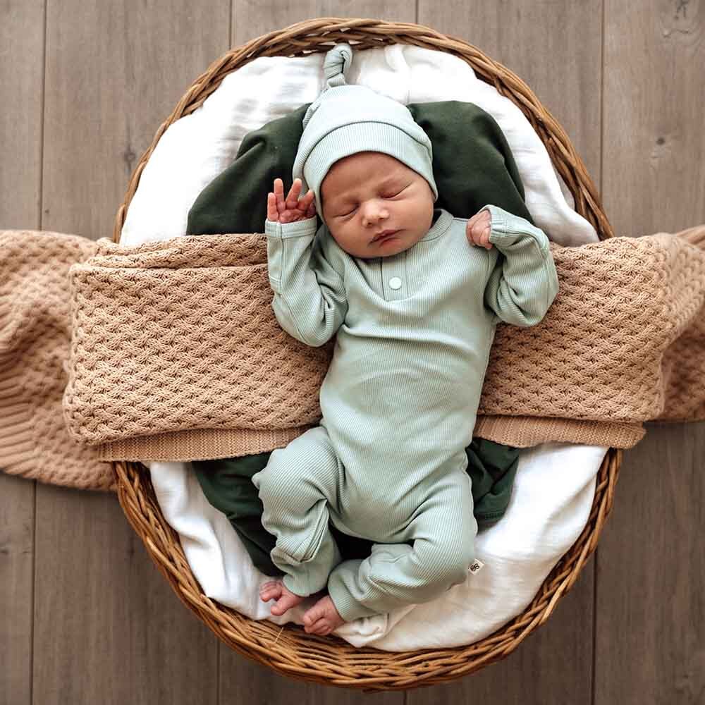 Baby in basket wearing the Sage Growsuit by Snuggle Hunny