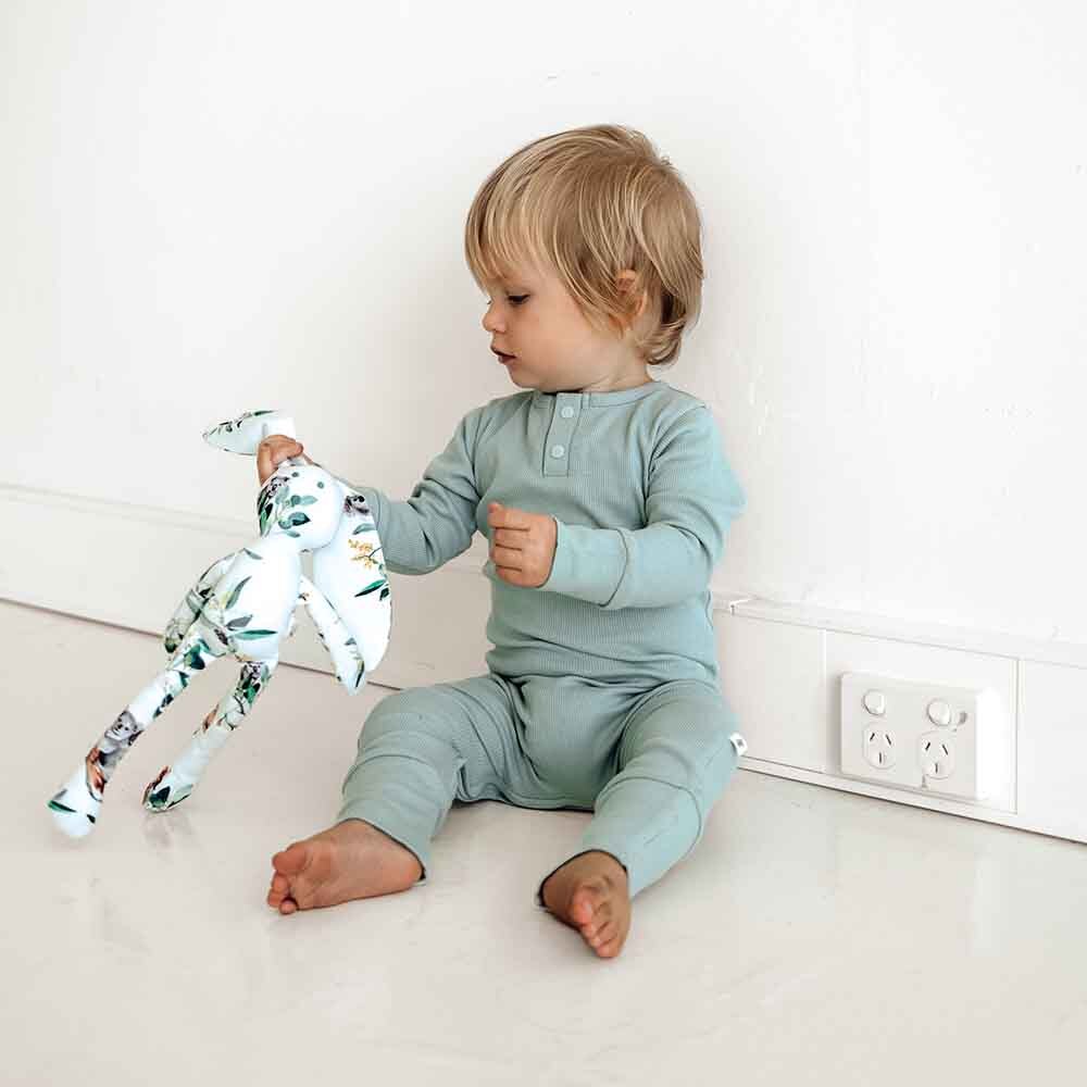 Toddler on floor wearing in the Sage Growsuit by Snuggle Hunny