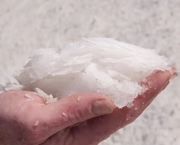 Person showing the salt flakes used in the Sea Salt Flakes 250g Refill Cube by Olsson's