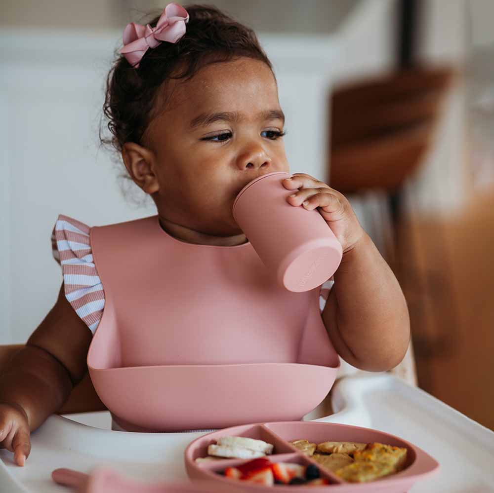 Toddler wearing the Silicone Bib Rose by Snuggle Hunny