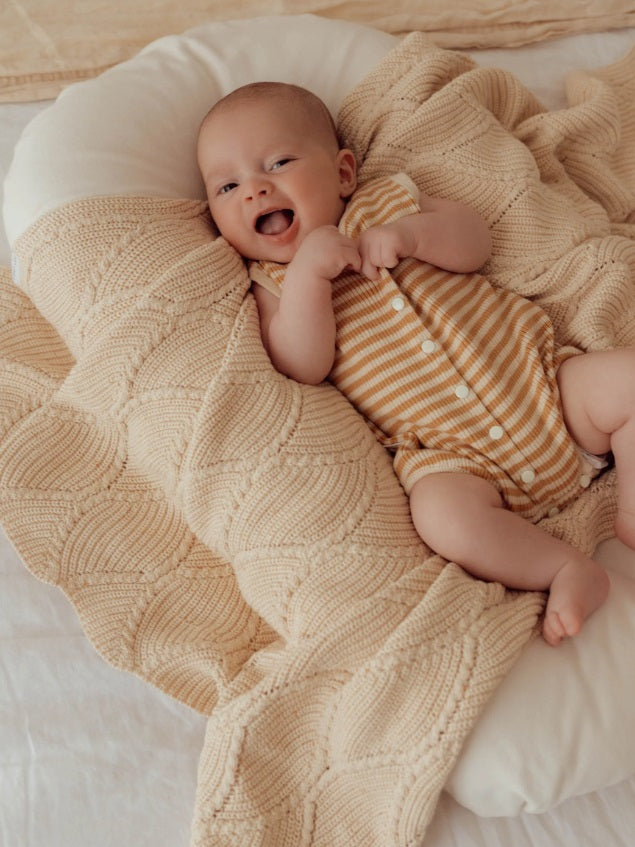 Baby laying down wearing the Summer Bubble Romper Golden Stripes by Ziggy Lou