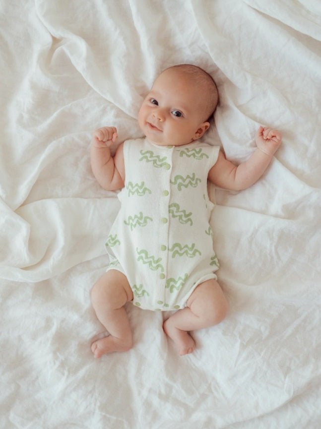 Baby laying down wearing the Summer Bubble Romper Waves by Ziggy Lou