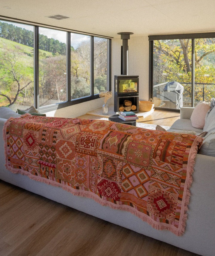 The Patchwork Rug by Salty Aura being used as a throw on a couch