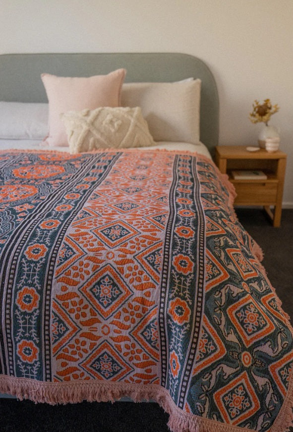 The Poppy Rug by Salty Aura being used on a bed